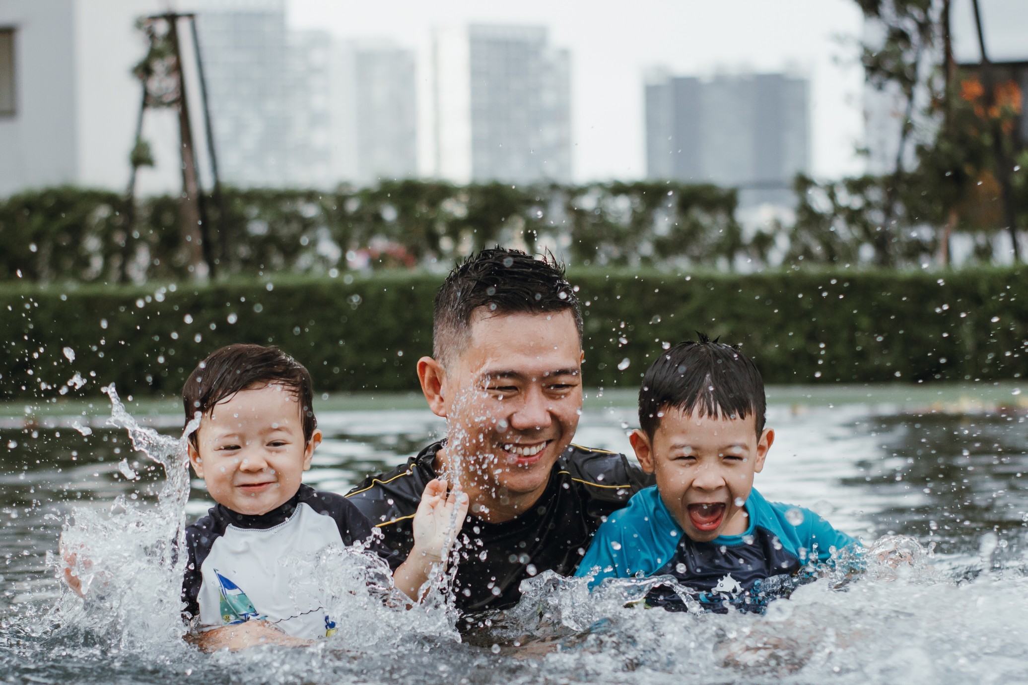 Dad splashing in the pool with his kids